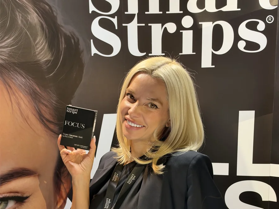 Elina Ivanova-Atanassov smiling at the Smart Strips stand with a box of FOCUS